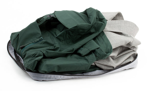 An open Medium Tri-Star Packing Cube in Northwest Sky (light grey) 120 Aether filled with shirts.